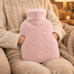 Mains au chaud dans la poche de la housse de bouillotte rose poudré