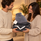 Homme offrant à une femme un sweat plaid gris, des chaussettes pilou-pilou et une housse de bouillotte grise